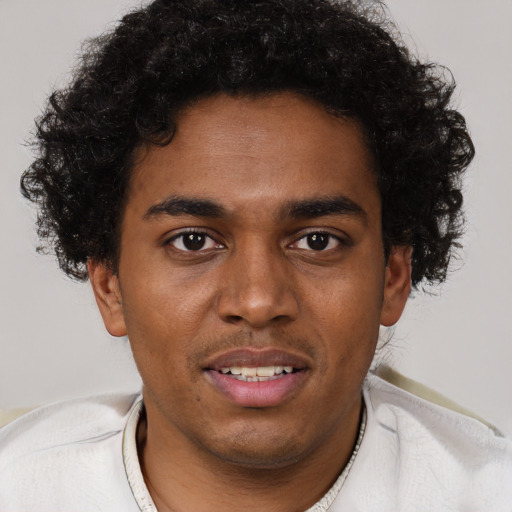 Joyful black young-adult male with short  brown hair and brown eyes