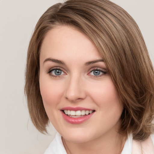 Joyful white young-adult female with medium  brown hair and green eyes