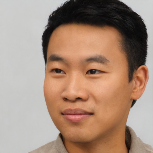 Joyful asian young-adult male with short  black hair and brown eyes