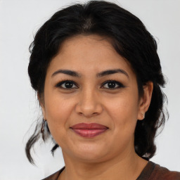 Joyful latino adult female with medium  brown hair and brown eyes