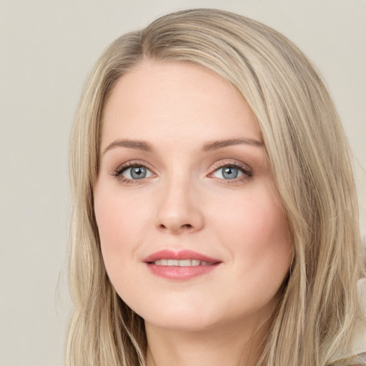 Joyful white young-adult female with long  brown hair and blue eyes