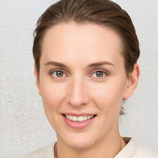 Joyful white young-adult female with short  brown hair and blue eyes