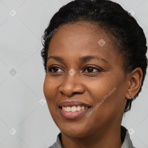 Joyful black young-adult female with short  black hair and brown eyes