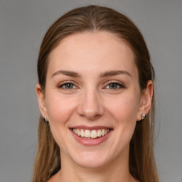 Joyful white young-adult female with long  brown hair and grey eyes