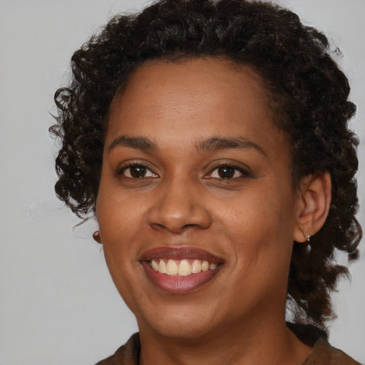 Joyful black young-adult female with medium  brown hair and brown eyes