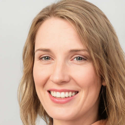 Joyful white adult female with long  brown hair and blue eyes