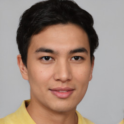 Joyful asian young-adult male with short  brown hair and brown eyes