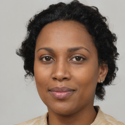 Joyful black adult female with medium  black hair and brown eyes