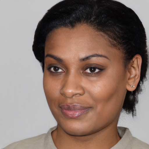 Joyful black young-adult female with short  black hair and brown eyes