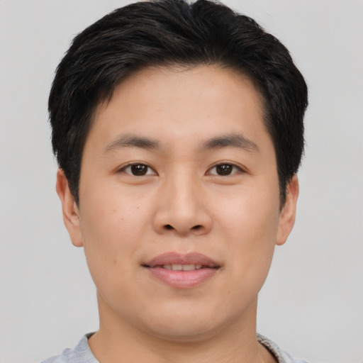 Joyful asian young-adult male with short  black hair and brown eyes