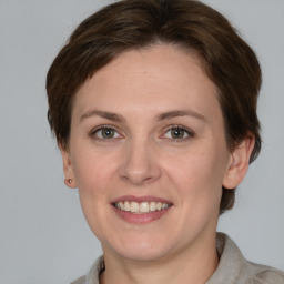 Joyful white young-adult female with medium  brown hair and grey eyes