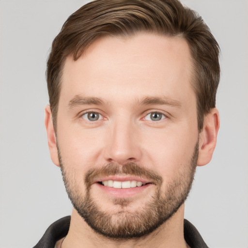 Joyful white young-adult male with short  brown hair and grey eyes