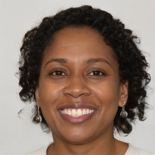 Joyful black adult female with medium  brown hair and brown eyes