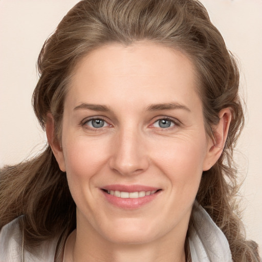 Joyful white young-adult female with long  brown hair and grey eyes