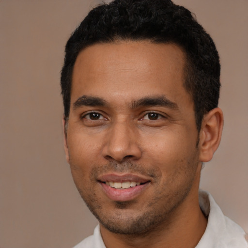 Joyful latino young-adult male with short  black hair and brown eyes