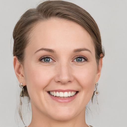 Joyful white young-adult female with medium  brown hair and grey eyes