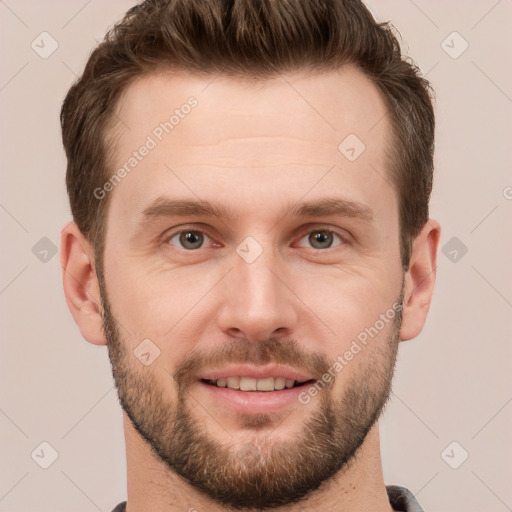 Joyful white young-adult male with short  brown hair and grey eyes