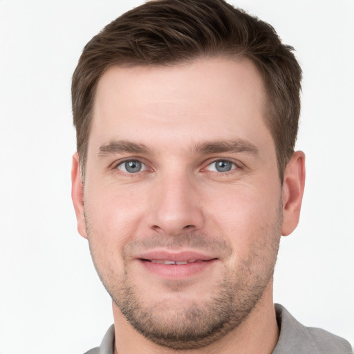 Joyful white young-adult male with short  brown hair and grey eyes