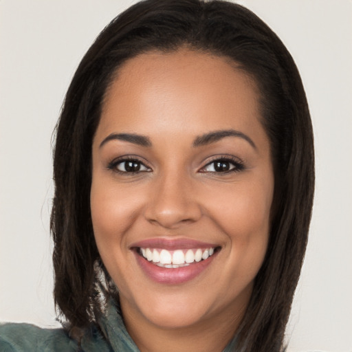 Joyful latino young-adult female with long  brown hair and brown eyes