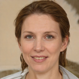 Joyful white adult female with medium  brown hair and green eyes