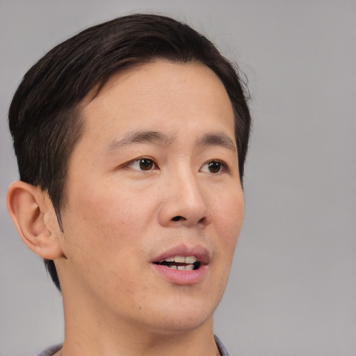 Joyful asian young-adult male with short  brown hair and brown eyes