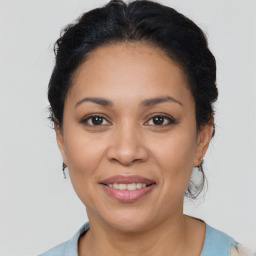 Joyful latino young-adult female with medium  brown hair and brown eyes