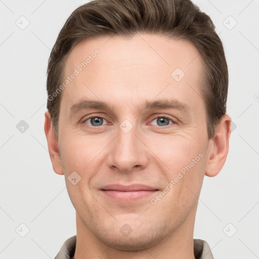 Joyful white young-adult male with short  brown hair and grey eyes