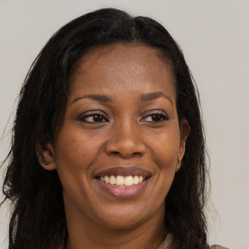 Joyful black young-adult female with long  brown hair and brown eyes