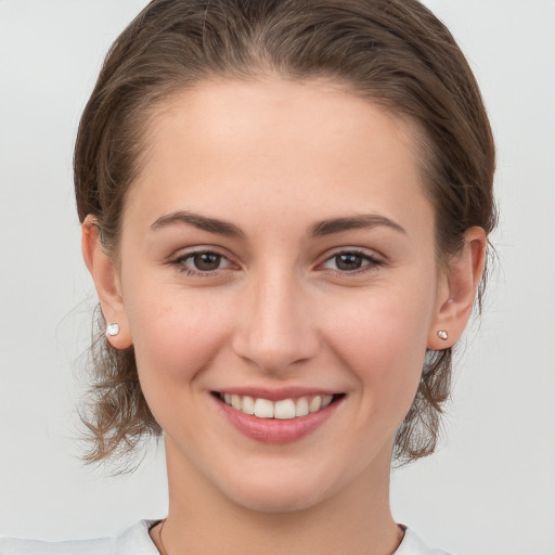 Joyful white young-adult female with medium  brown hair and grey eyes