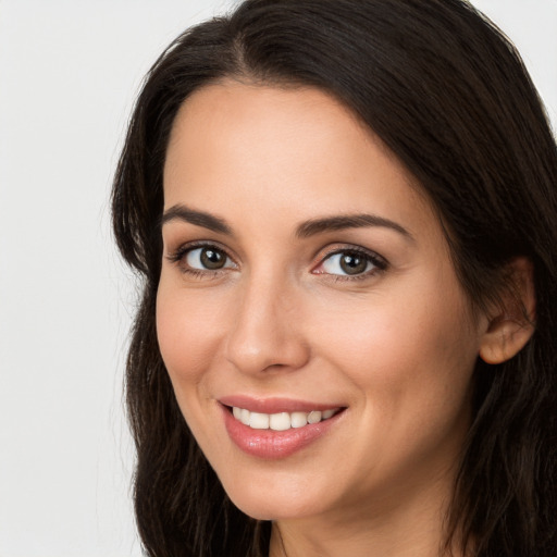 Joyful white young-adult female with long  brown hair and brown eyes