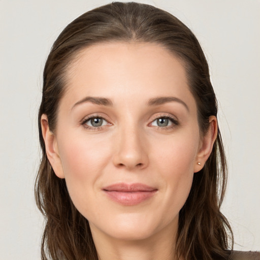 Joyful white young-adult female with long  brown hair and grey eyes