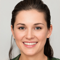 Joyful white young-adult female with medium  brown hair and green eyes