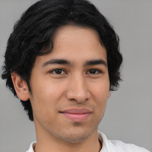 Joyful latino young-adult male with short  brown hair and brown eyes