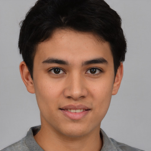 Joyful asian young-adult male with short  brown hair and brown eyes