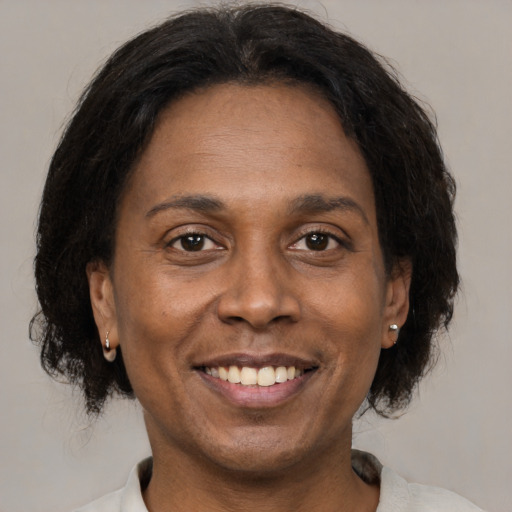 Joyful black adult female with medium  brown hair and brown eyes