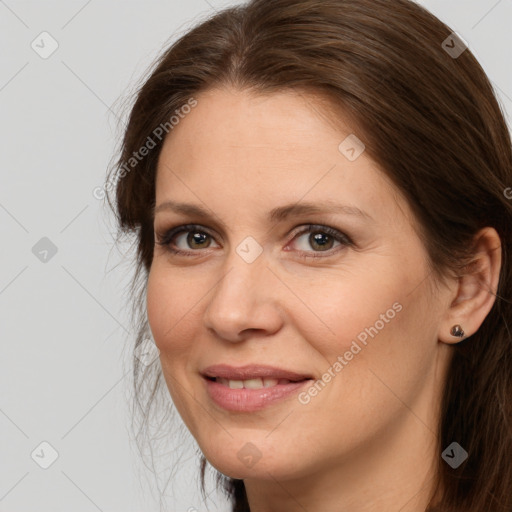 Joyful white adult female with long  brown hair and brown eyes