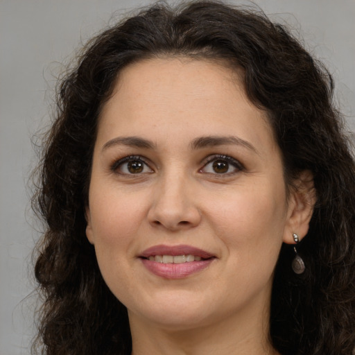 Joyful white adult female with long  brown hair and brown eyes