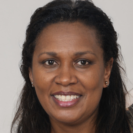 Joyful black adult female with long  brown hair and brown eyes