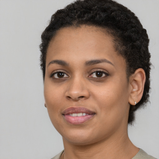 Joyful black young-adult female with short  black hair and brown eyes