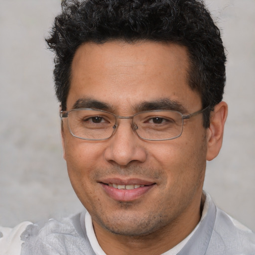 Joyful white adult male with short  black hair and brown eyes