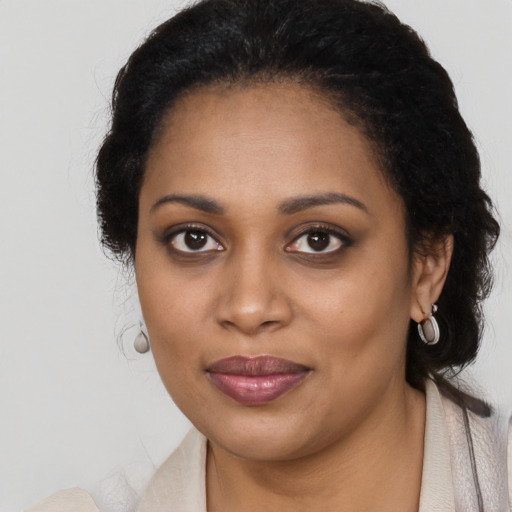 Joyful black young-adult female with long  brown hair and brown eyes