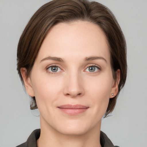 Joyful white young-adult female with medium  brown hair and grey eyes