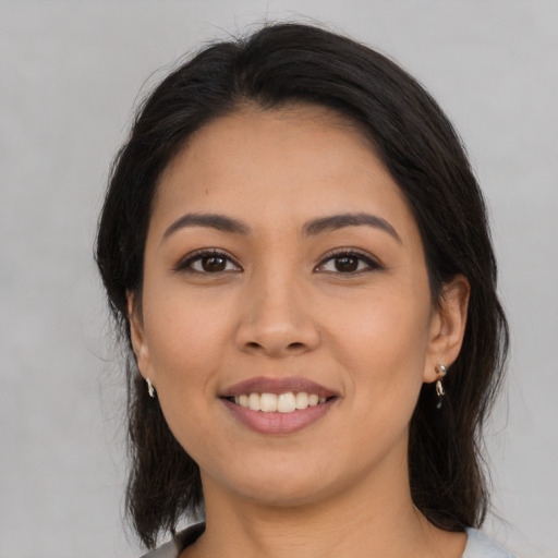 Joyful latino young-adult female with medium  brown hair and brown eyes