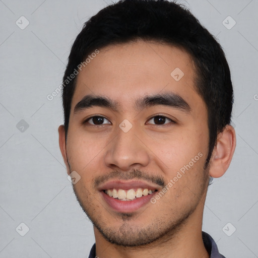 Joyful latino young-adult male with short  black hair and brown eyes