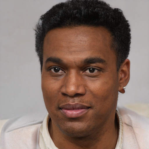 Joyful black young-adult male with short  black hair and brown eyes