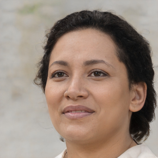 Joyful latino adult female with medium  brown hair and brown eyes