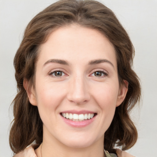 Joyful white young-adult female with medium  brown hair and green eyes