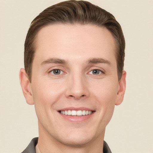 Joyful white young-adult male with short  brown hair and grey eyes