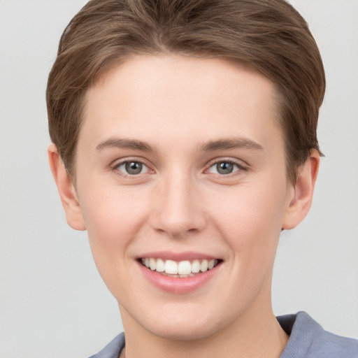 Joyful white young-adult female with short  brown hair and grey eyes