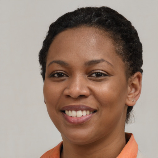 Joyful black young-adult female with short  black hair and brown eyes
